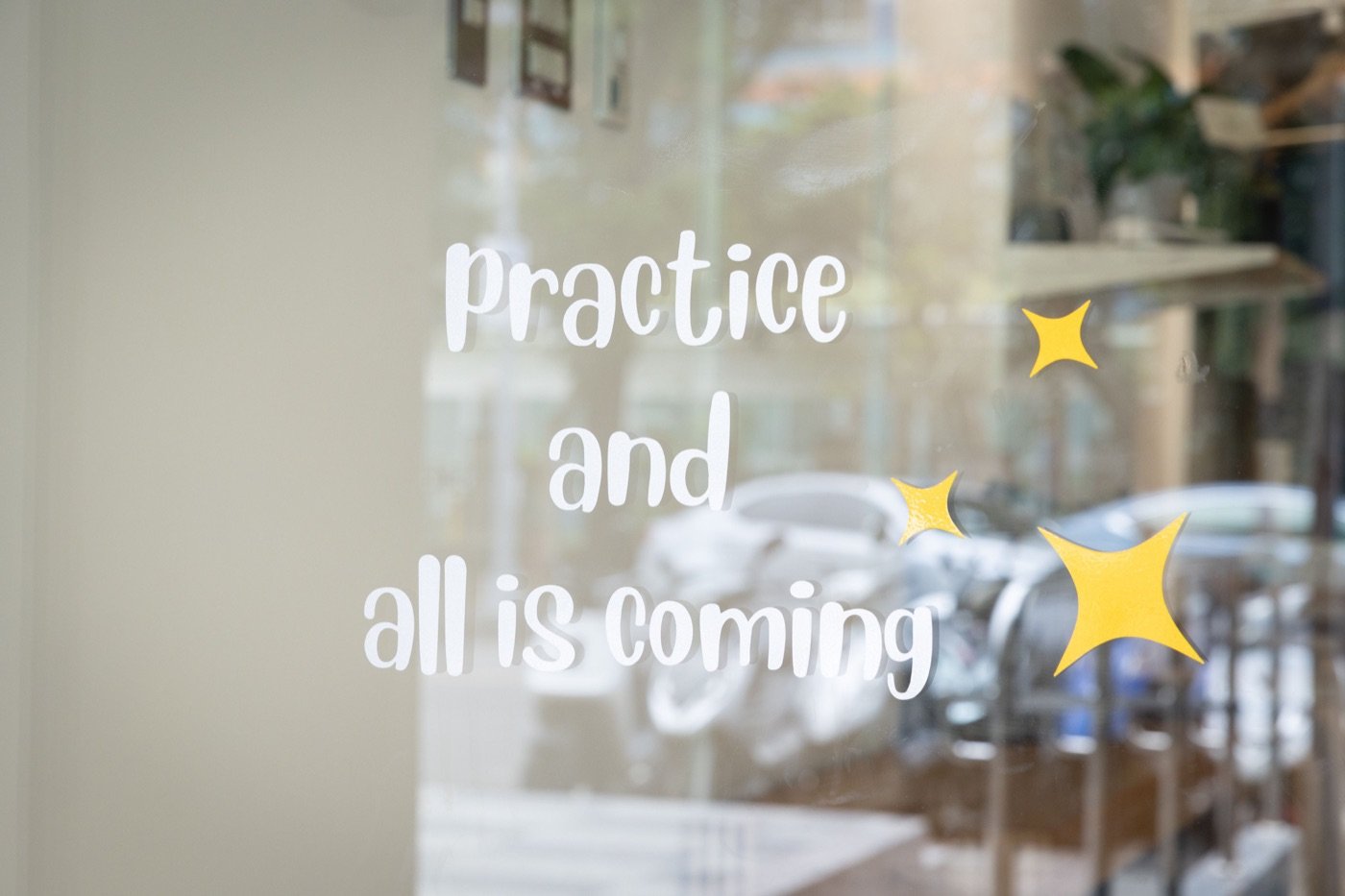 貓牛瑜伽教室玻璃上的 practice and all is coming 字樣